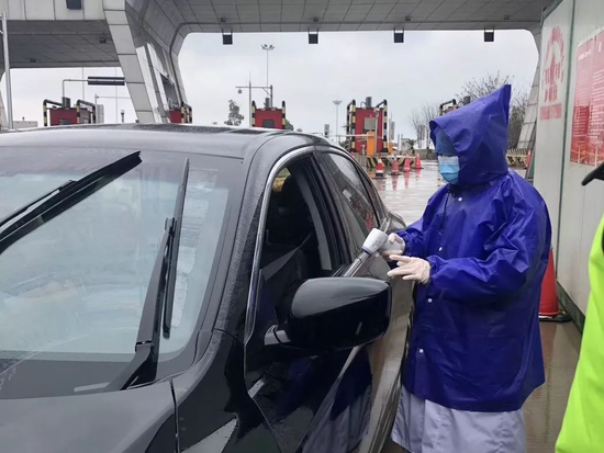 行政党支部党员冒雨在高速出口测量体温