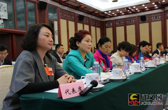 全国人大代表、江西省水利科学研究院副院长傅琼华（右一）审阅政府工作报告。正义网记者 姜洪 摄 