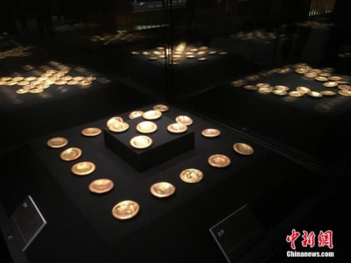 3月2日,北京,从江西南昌汉代海昏侯墓出土的441组件文物在首都博物馆亮相。该墓的发掘历时5年时间,其墓主身份一直引发猜测。在展览现场的新闻发布会上,考古人员确认,墓主身份确为此前第一代海昏侯、汉废帝刘贺。图为展出的金饼。 中新网记者 翟璐 摄