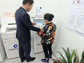 工作人员向老人讲解宣传折页（拍摄：张丽玲）