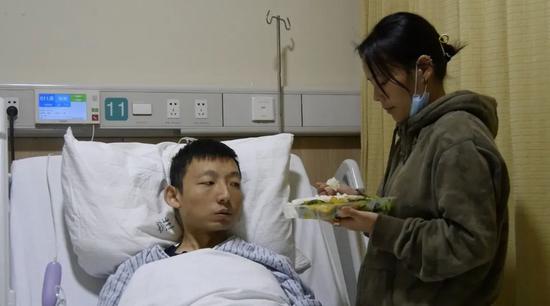 姚策妻子在给躺在病床上的姚策喂饭。新京报记者 刘名洋 摄