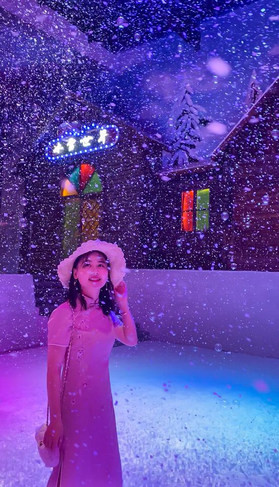 身处浪漫飘雪烟雾泡泡中的游客