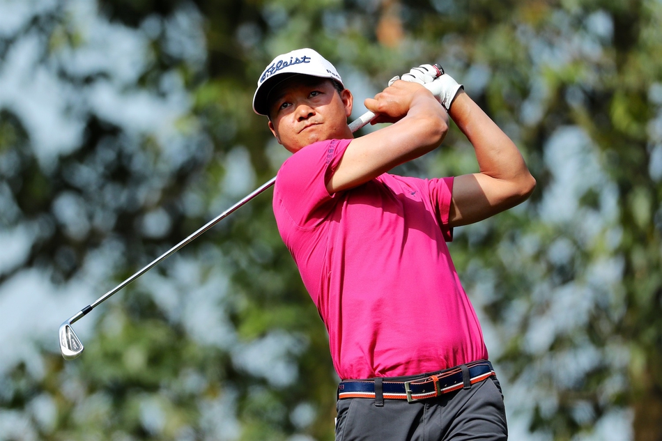 球员刘晏玮在全神贯注地准备推杆，阳光洒在果岭上，营造出大赛独有的紧张与宁静交织的氛围。