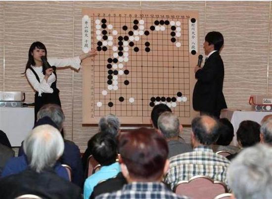 日本棋手万波奈穗三段搭档小林觉九段进行大盘讲，底下坐的全是中老年围棋爱好者