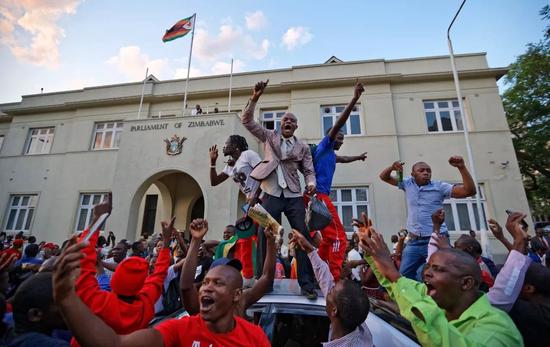 ▲11月21日，津巴布韦议会大楼外，穆加贝辞职的决定令游行群众欢呼雀跃。（美联社）