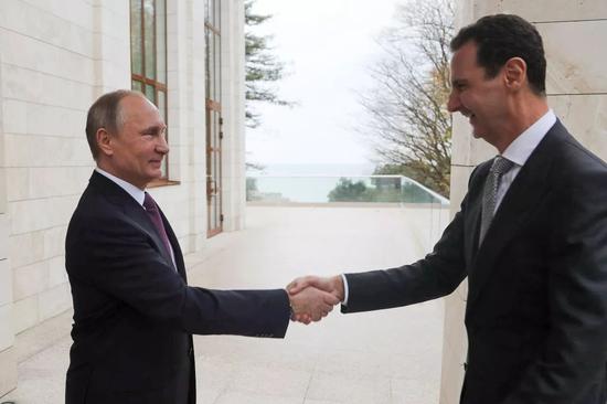 11月20日，在俄罗斯索契，俄罗斯总统普京（左）与叙利亚总统阿萨德握手。新华社/美联