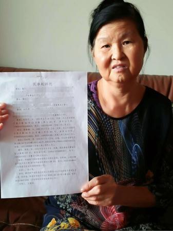 崔惠生的妻子展示崔家的上诉书。受访者供图
