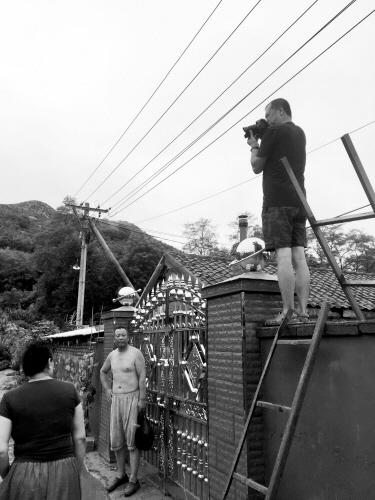 本报记者(右)在拍摄岫岩灾区情况