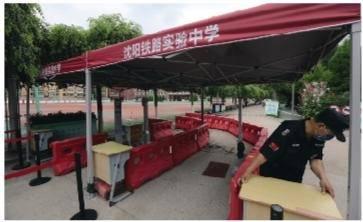 在沈阳铁路实验中学考点,保安在测温通道布置场地。