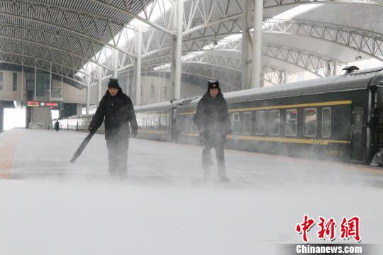 工作人员在站台除雪,确保旅客乘降安全。 钟欣 摄