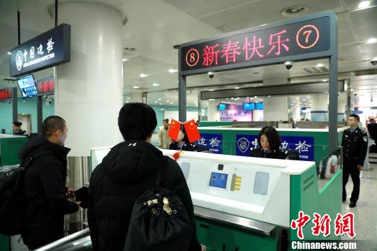 边检验证台显示屏显示“新春快乐”字样欢迎旅客回家 王景巍 摄