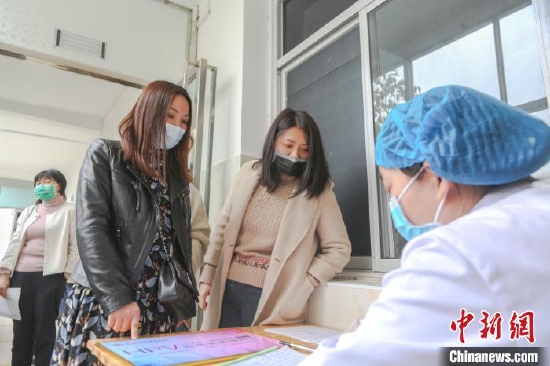 资料图:江西省宜春市靖安县子宫颈癌防治研究所,前来接种疫苗的女性正在排队登记个人信息。 刘力鑫 摄