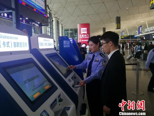民警正在指导旅客操作“自助签注机”办理签注业务。 王景巍 摄