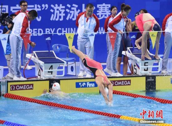 图为中国队第三棒张雨霏和第四棒杨浚瑄在比赛中交接棒。中新社记者 侯宇 摄