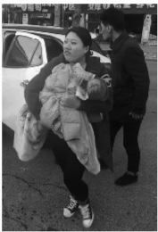 家人抱着烫伤婴儿下车。