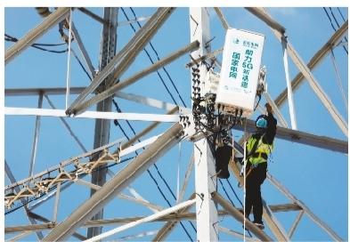 电力工人对输电杆塔上的通信基站设备进行调试。本报记者 刘大毅 摄
