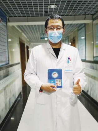 大连市第三人民医院医生马林捧着来自武汉的徽章牌照留念。（图片由受访者提供）