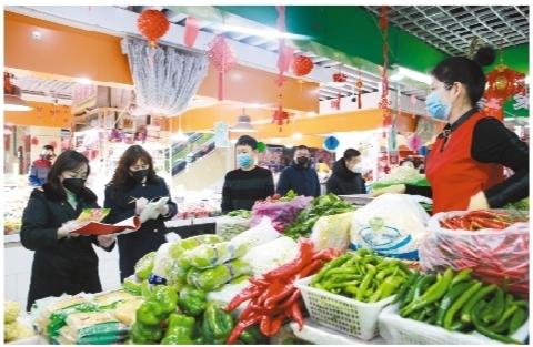 我省市场监管人员在农贸市场进行检查,保障居民“菜篮子”安全。