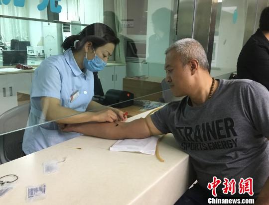 图为阿拉善电业局职工汪有兴进行验血。　郭香 摄