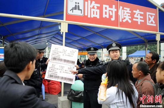 资料图：民警在火车站现场教旅客识别假票，以使旅客避免上当受骗。中新社记者 蒋雪林 摄