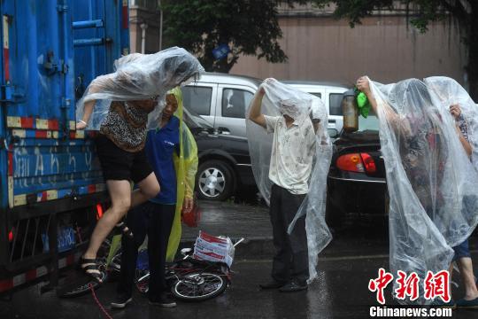 图为重庆突降暴雨民众穿着自制雨衣。 陈超 摄