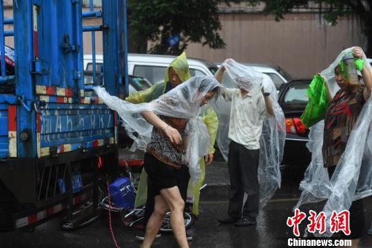 图为重庆突降暴雨民众穿着自制雨衣。 陈超 摄