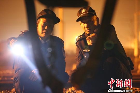 夜幕降临,唐楚伟和辅警在线路中巡查。 王荣鑫 摄