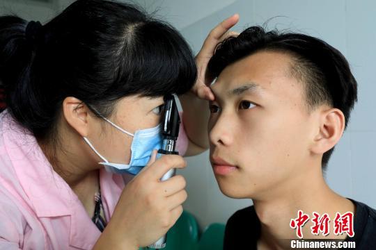 一名医生在为大学生检查眼睛。 谭凯兴 摄