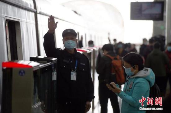 ↑ 资料图：北京地铁昌平线沙河高教园站的工作人员做出发车前的确认手势。 中新社记者 侯宇 摄