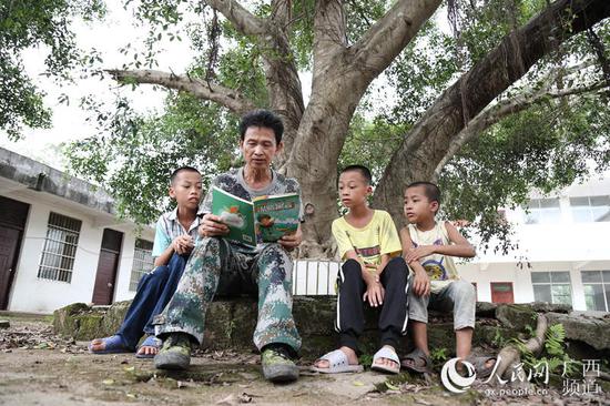 图为梁志雄在教学生读书。韦世仙 摄影