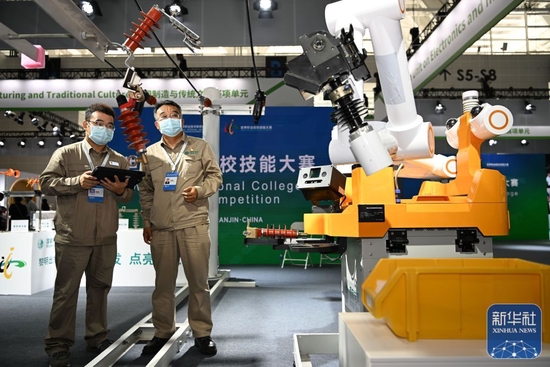 在国家会展中心（天津），工作人员在首届世界职业院校技能大赛上操作演示人工智能配网带电作业机器人（2022年8月19日摄）。新华社记者 孙凡越 摄