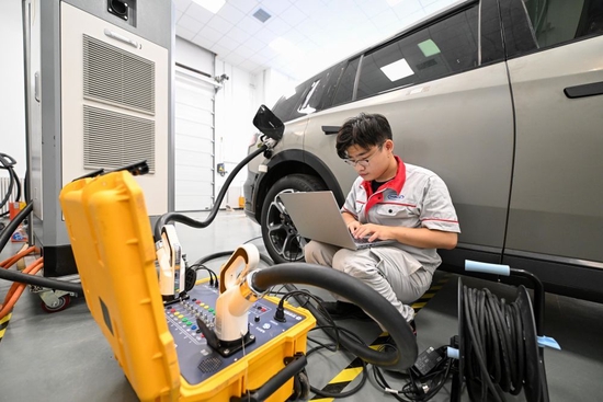  ↑9月14日，在中汽中心新能源汽车科技创新基地充电技术部，工作人员测试某款新能源车型充电兼容性能。