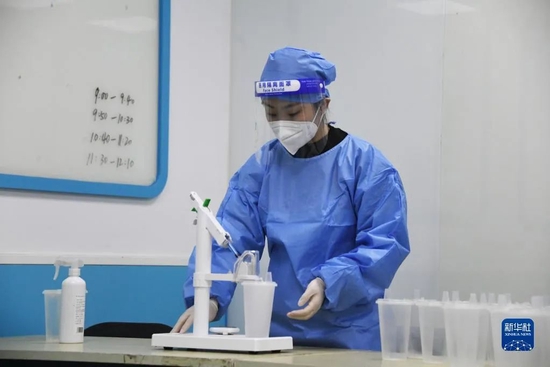 12月21日，在北京市海淀区海淀街道新冠疫苗接种点，医护人员进行吸入式新冠疫苗接种前的准备工作。新华社记者 任超 摄
