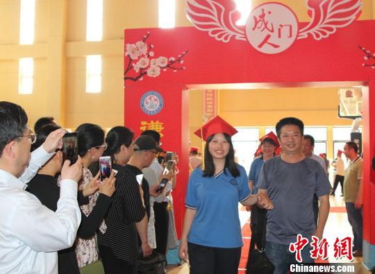 家长陪着孩子走过成人门。 曾蓓 摄