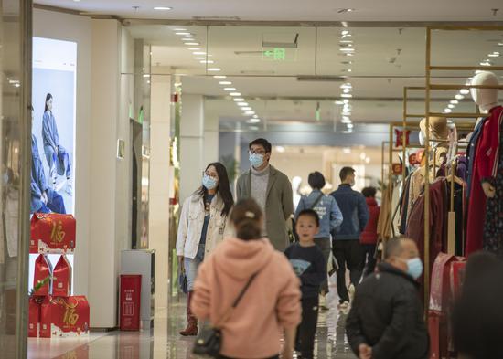 2月15日,在重庆市江北区观音桥商圈一商场内,市民在服装层选购衣服。新华社记者 黄伟 摄