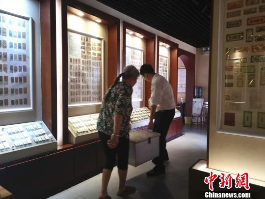 李广智与母亲王老四抬着藏品,送往别地展出。 朱柳融 摄
