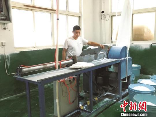 蔡建国在操作塑料干研磨机 沈晓颜 摄