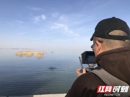 视频作者周健伟正在湖面取景。