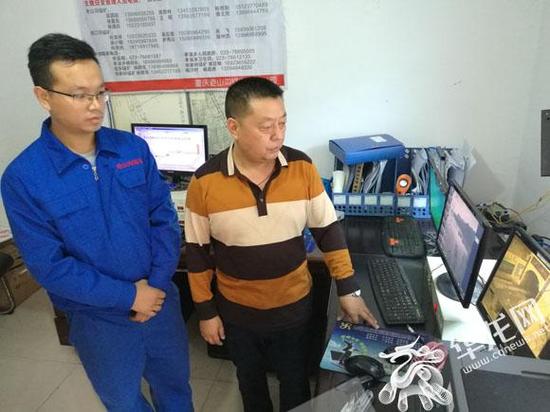 重庆老山沟锰业有限公司总工程师田仁安(右)在监控室督导矿井安全监管情况。记者 伊永军 摄