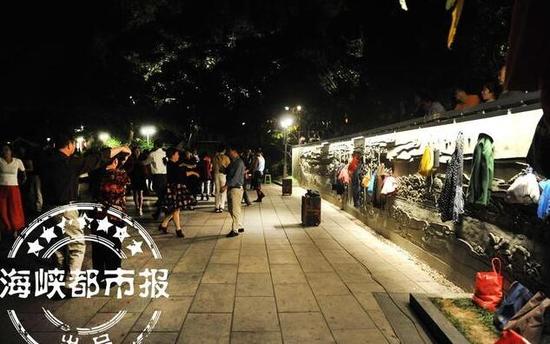 部分跳广场舞的市民,将物品直接挂在浮雕上