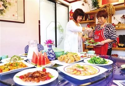玉石庄园女主人郭姝莹(左)正在向其他民宿主人传授烹饪技艺。