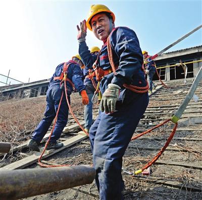 工人们小心拆下轮机厂房一百多年的屋瓦