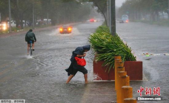 菲律宾民众顶着狂风暴雨出行。