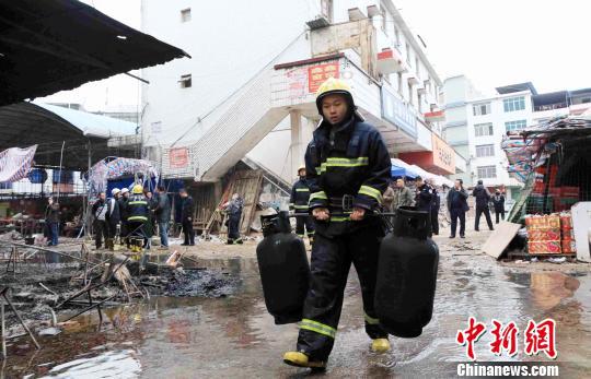 消防救援人员正在清理抢救处理的煤气罐。 谭凯兴 摄