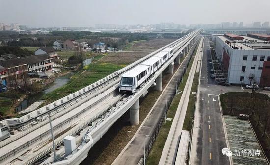 上海,2018年3月23日,地铁列车行驶在上海首条无人驾驶APM线路——浦江线上(无人机航拍)。 新华社记者丁汀摄