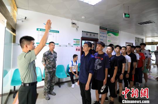 一名专武干部指挥大学生参加体检。 谭凯兴 摄