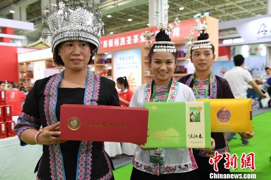 图为身着民族服饰的广西茶商现场宣传桂茶。 李爱平 摄