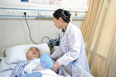 李霞绯在病床前悉心照顾丈夫。