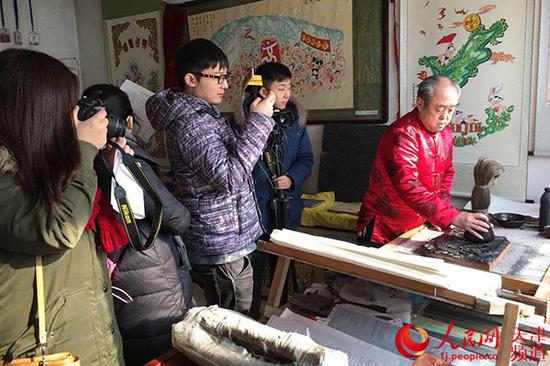 年画传承人董静(右)展示东丰台木版年画制作过程。
