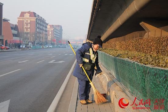 2018年2月16日(正月初一)天津环卫工于春萍在黑牛城道和解放南路交口清扫道路,路边见不到扫之不尽的鞭炮皮。张静淇/摄